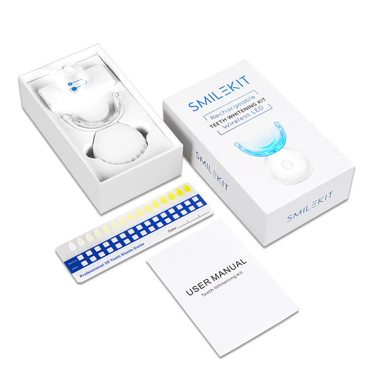 SMILEKIT teeth whitening kit with packaging, LED light, trays, and user manual on a white background.

