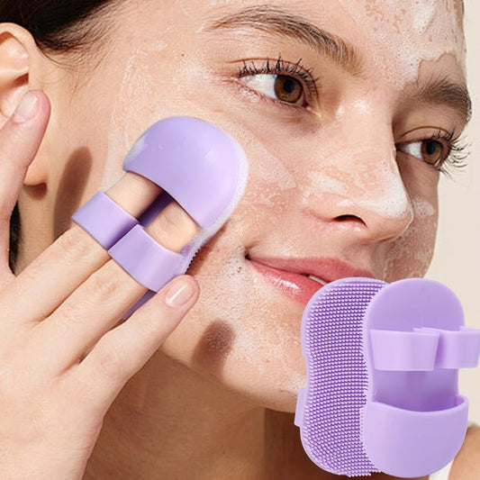 Woman using a purple facial cleansing brush on her face with a beige background

